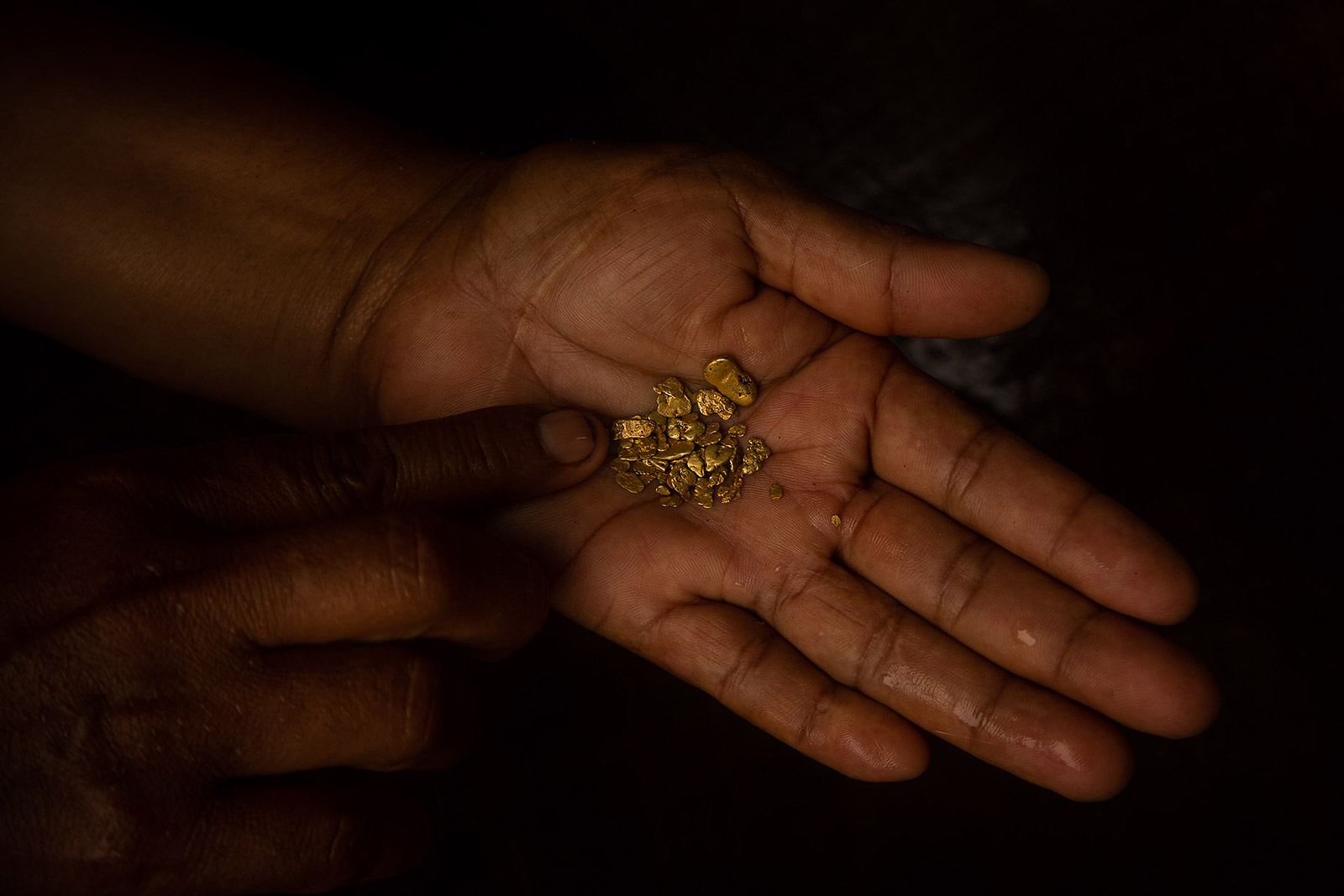 Image showing an Ecuadorian miner holding gold nuggets on her hand