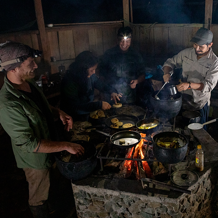 Image showing a group of biologists cooking besides a camp fire